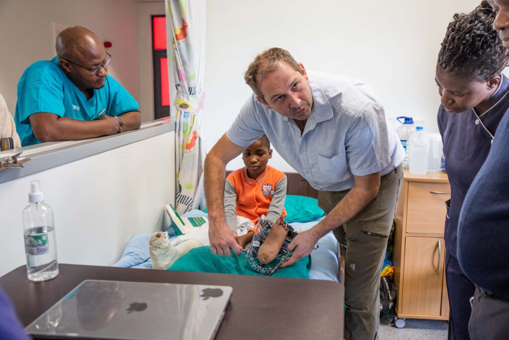 Dr Sam showing the CURE Zimbabwe staff how to operate Peter Moyo's ilizarov frame